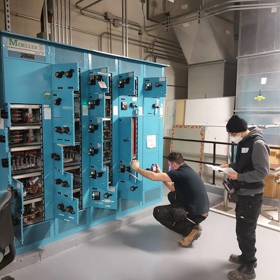 Electrix electricians performing an infrared inspection on live motor control equipment.